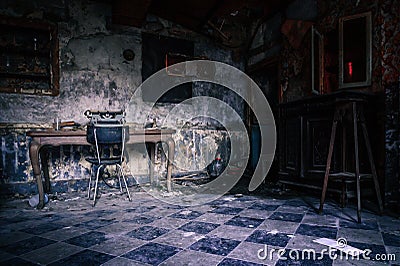 View inside a gloomy abandoned house with a typewriter in a workplace room Stock Photo