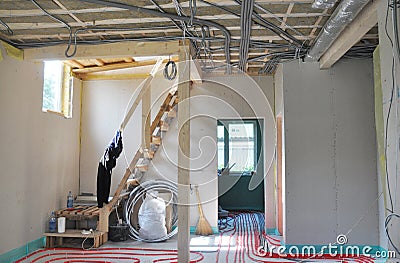 A view from inside the house under construction with fiberglass insulated ceiling, indoor electric wiring in metal conduit, Stock Photo