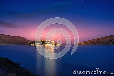 View of the island of Spinalonga at night with nice clouds and calm sea. Here were isolated lepers. Stock Photo