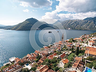 View of the islands in the Bay of Kotor over the red roofs of old houses. Perast, Montenegro. Drone Stock Photo