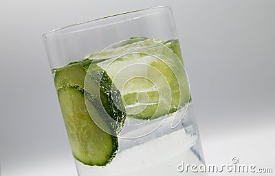View on isolated glass with sparkling tonic water, cucumber slices, gin and ice cubes Stock Photo