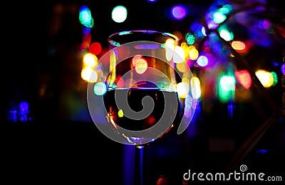 View on isolated shot glass with rum. Bokeh with vibrant colors and blurred bottles background Editorial Stock Photo