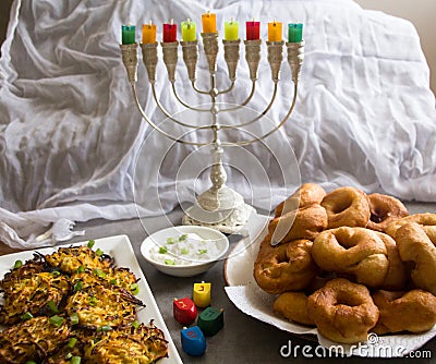 Jewish holiday Hanukkah symbols against white background; traditional spinning top, menorah traditional candelabra, `Sfinj `Donu Stock Photo