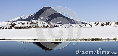 View of the Karymskaya Sopka and the reflection of the volcano cone in the lake water Stock Photo