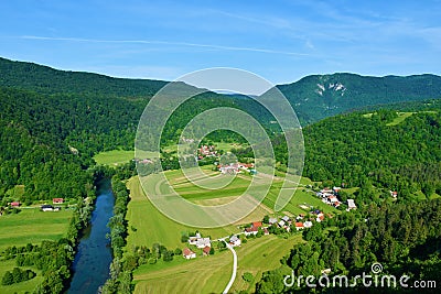 View of Kolpa river with farmland and forest covered hills Stock Photo