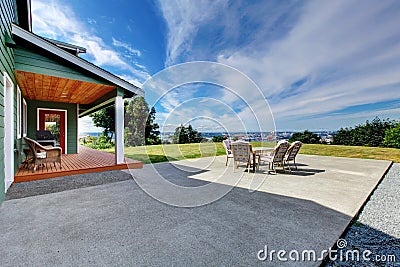 VIew of large concrete floor patio area with table set at backyard Stock Photo