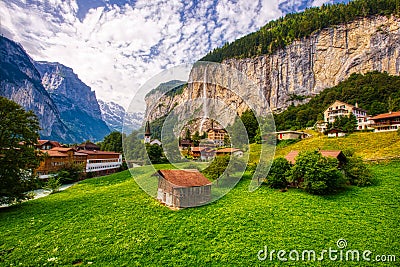 View of Lauterbrunnen town in Swiss Alps valley with gorgeous Staubbach waterfalls in the background, Switzerland Editorial Stock Photo