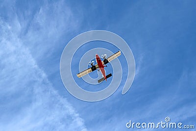 Small Airplane Flying at Low Altitude Under Blue Sky Viewed from Below Stock Photo