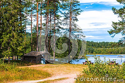 View of a lonely lake in Sweden with a wooden hut on a sunny day Stock Photo