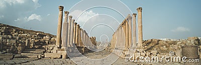 A view looking down the Cardo showing stone carved columns and paved street at the ancient city of Jarash or Gerasa, Jerash in Stock Photo