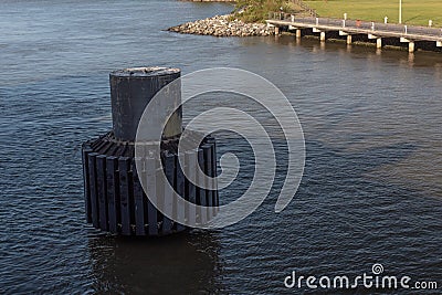 View looking down on a modern dolphin pier piling in the shadow of a ship Stock Photo