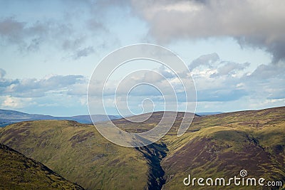 View looking east above Glen Doll towards rolling Scottish mountains with white clouds Stock Photo