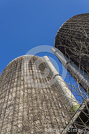 View looking up the face of two old concrete silos against a blue sky Stock Photo