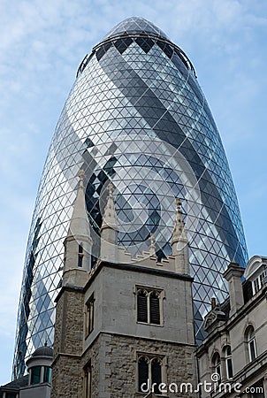 View looking up at the iconic Gherkin Building, London UK. Church of St Andrew Undershaft is in the foreground. Editorial Stock Photo