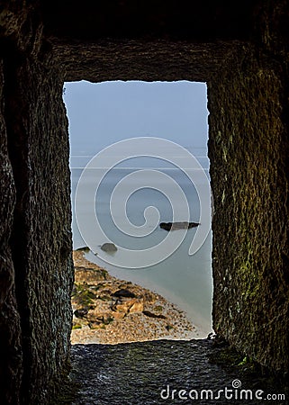 A view from the loophole to the sea in Mont Saint Michel, Normandy, France Stock Photo