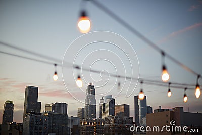 View Of Los Angeles Skyline At Sunset With String Of Lights In Foreground Stock Photo