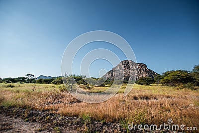 A view of the male hill at Tsodilo Hills, a UNESCO world heritage site featuring ancient San rock paintings. Pictured amid grassy Stock Photo