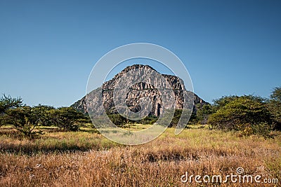 A view of the male hill at Tsodilo Hills, a UNESCO world heritage site featuring ancient San rock paintings. Pictured amid grassy Stock Photo