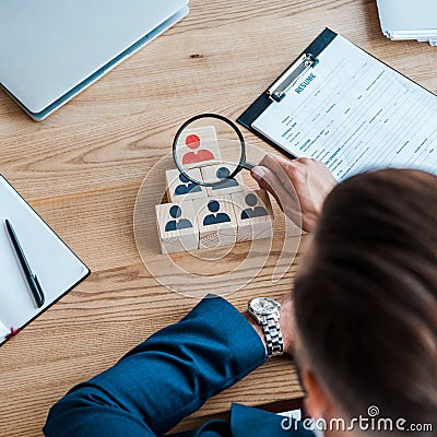 View of man holding magnifier near wooden cubes Stock Photo