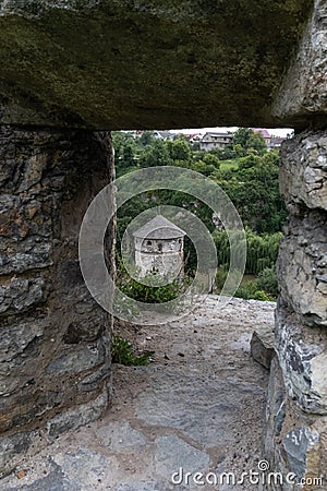 View of the medieval stone tower through the loophole in the stone wall. Stock Photo