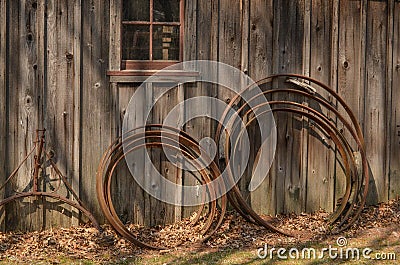 Wagon Wheel Rims Leaning on a Rustic Building Stock Photo