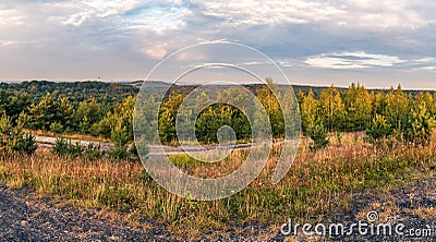 view from the mining heap on forests and other heaps and mining infrastructure. panorama of the autumn forest seen from the mining Stock Photo