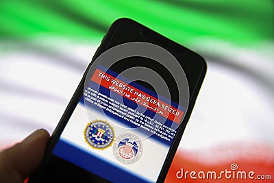View on mobile phone screen with FBI notification this website has been seized, blurred iran flag background Editorial Stock Photo