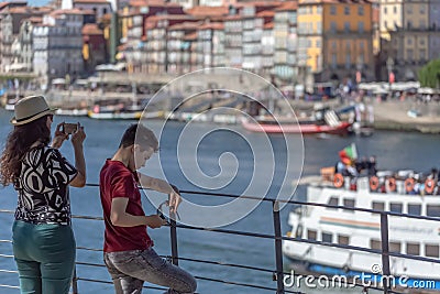 View of a mother and son looking and taking pictures at the Douro river and Porto downtown Editorial Stock Photo
