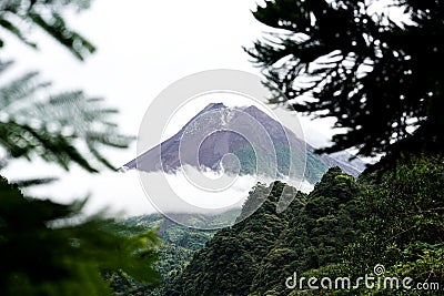 View of Mount Merapi in the morning, and slightly covered by clouds. Potentially eruptive volcano Stock Photo