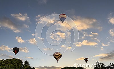 View of Multiple Multi Colored Hot Air Balloons Floating in a Beautiful Morning Blue Sky With Thin Clouds Editorial Stock Photo