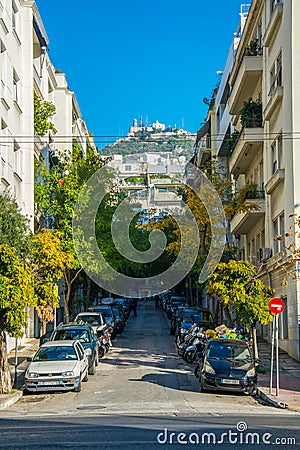 view of a narrow street in the central athens with lycabetus hill at the end....IMAGE Editorial Stock Photo