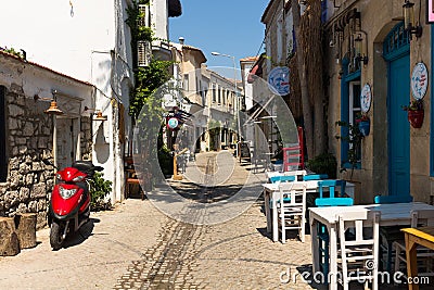 View of a narrow street and old, historical, traditional stone houses in famous, touristic Aegean town called Alacati. Editorial Stock Photo