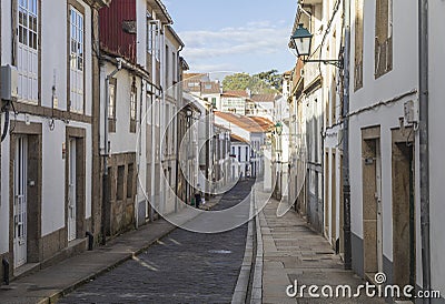 View of a narrow street of Santiago de Compostela, the final destination of the pilgrimage Camino de Santiago, Galicia, Spain. Editorial Stock Photo