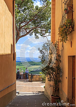 View from the narrow streets of Montepulciano. Tourists enjoying amazing view of Tuscany countryside. Italy. Stock Photo