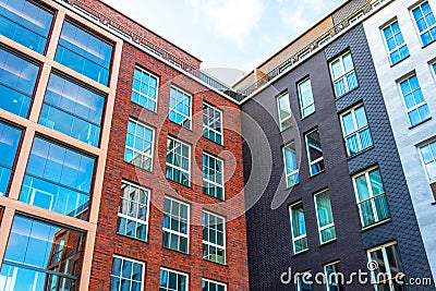 View of a new residential rectangular modern inside corner red and black brick house with classic windows Stock Photo
