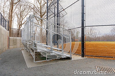 View of nondescript high school softball field aluminum bleachers located behind the backstop Stock Photo