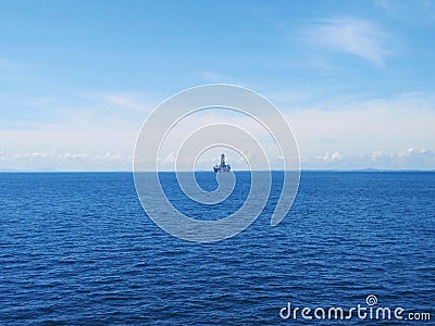 View of an offshore drilling rig at open seas. A drilling rig is an integrated system that drills oils in the subsurface. Stock Photo