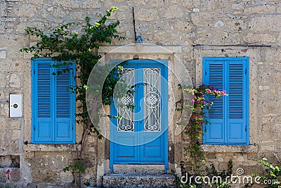 View of old, historical, traditional stone house with blue colored door and windows in famous, touristic Aegean town Editorial Stock Photo