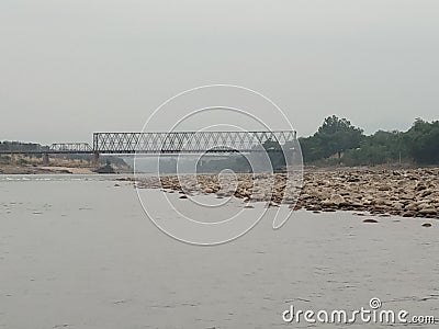 view of the old iron bridge over Chenab river in Akhnoor on a cloudy day Stock Photo
