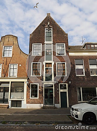 View an old stone house with shutters on the windows in cloudy weather with clouds in the city of Vlaardingen Stock Photo