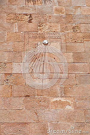 View of an old sundial located on an ancient wall. Roman numbers written on the rectangular board. Stock Photo