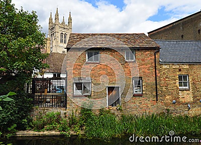 View of old waterside buildings by Hen Brook St Neots with St Marys Church Tower in background. Stock Photo