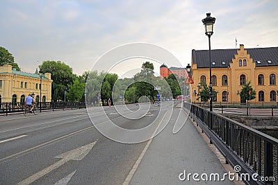 View on one of central streets in Uppsala, Sweden, Europe. Small bridge over river , yellow buildings, red castle far away. Stock Photo