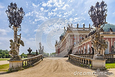View of one of the entrances of Das Neue Palast with its baroque statues, wrought iron lanterns, and a part of the palace garden Editorial Stock Photo