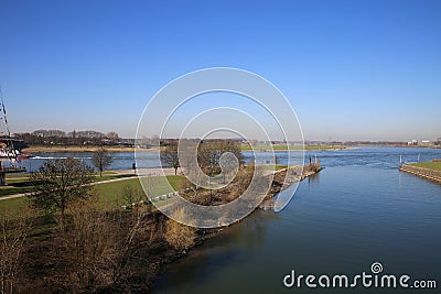 View over green pasture pensinsula MÃ¼hlenweide at river rhine against blue sky in winter - Duisburg, Germany Stock Photo