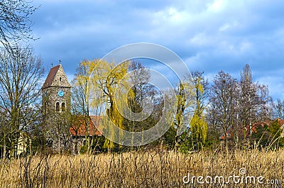 View over reeds on a small village church built of fieldstones in Berlin Stock Photo