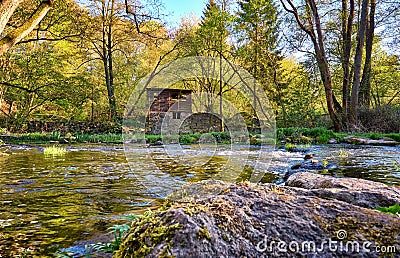 View over the stones in the river to a ruin in the forest Stock Photo