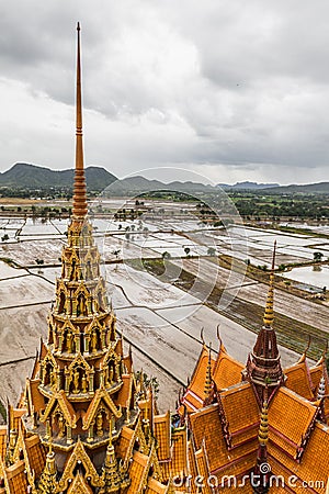 View of pagoda of Wat Tham Sua temple with beautiful paddy field in water in the background during raining Stock Photo