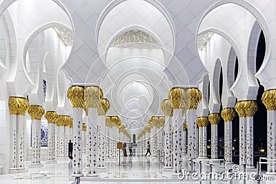 View of the passage through the arches of The Sheikh Zayed Grand Mosque with marble columns ornate with gold and mosaics pictures Editorial Stock Photo