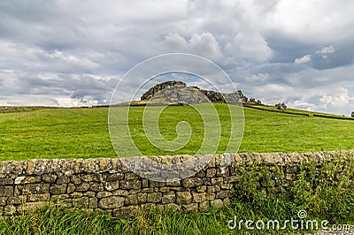 A view past a dry stone wall towards the Almscliffe crag in Yorkshire, UK Stock Photo